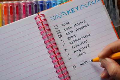 Close-up of hand writing on book