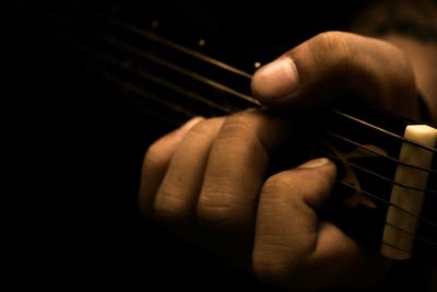 Close-up of man playing guitar