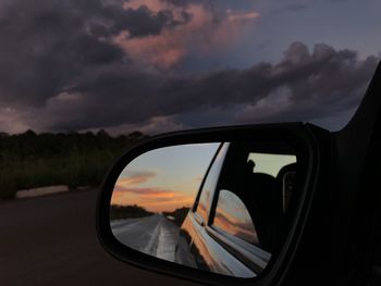 Reflection of sky on side-view mirror of car