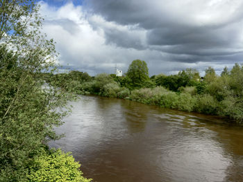 Scenic view of river against cloudy sky