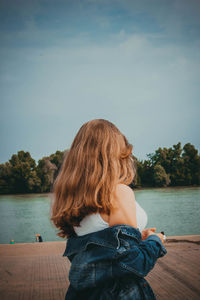 Rear view of young woman looking at lake