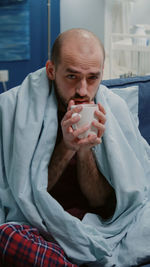 Portrait of young man drinking milk in hospital