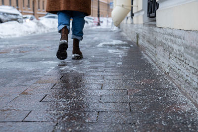 Low section of woman walking on footpath