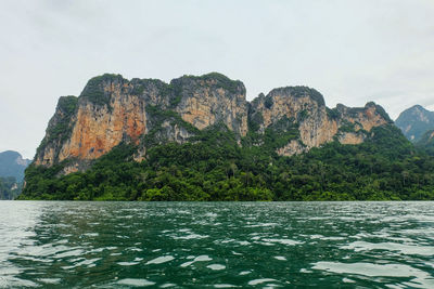 Rock formations by sea against sky