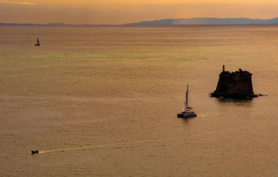 Sailboat in sea at sunset