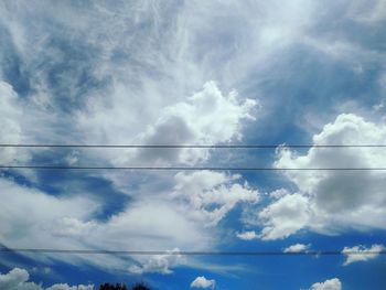 Low angle view of power cables against sky