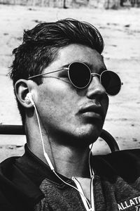 Close-up of young man wearing sunglasses at beach