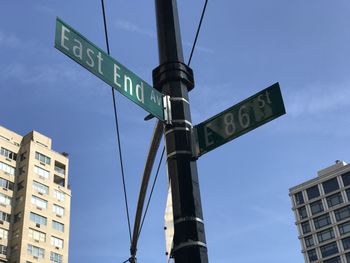 Low angle view of road sign and buildings in city