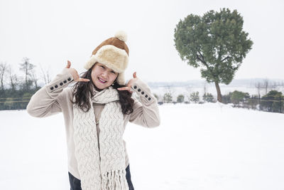 Portrait of smiling young woman standing in snow