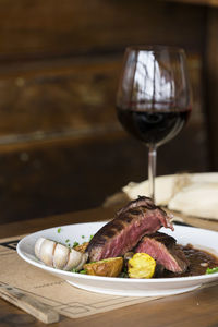 Beef steak and red wine served on table