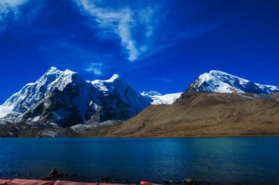 Scenic view of snowcapped mountains against blue sky