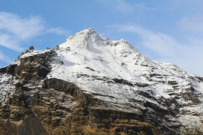 Low angle view of snowcapped mountains against sky