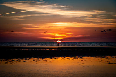 Scenic view of beach against sky during sunset