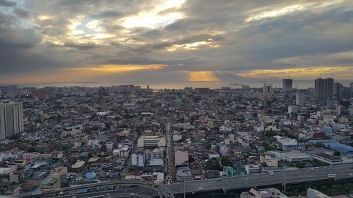 Aerial view of city against cloudy sky