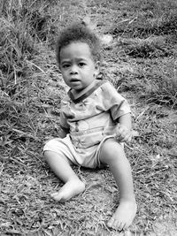 Portrait of cute boy sitting on field