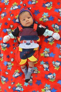 High angle view of cute baby lying on bed