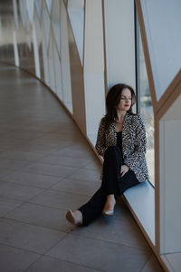 Portrait of young woman sitting on floor