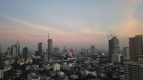 Aerial view of buildings in city against sky during sunset