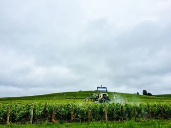 Scenic view of grassy field against cloudy sky