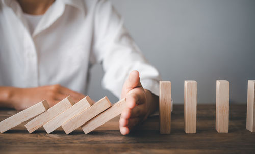 Midsection of businessman holding wooden blocks on table