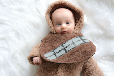 Directly above portrait of cute baby boy lying on fur blanket