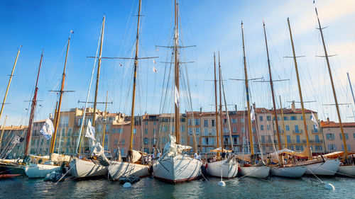 Sailboats moored in sea against sky