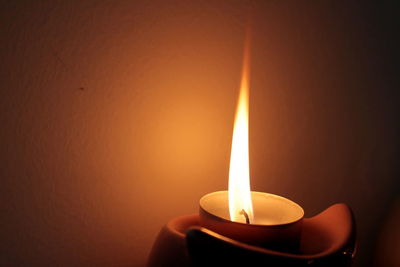 Close-up of lit candle in darkroom