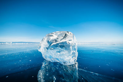 Close-up of frozen sea against blue sky