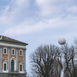 Bare tree against built structure