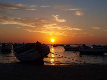 Boats in calm sea at sunset