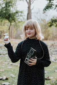 Portrait of woman standing against tree