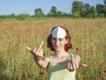 Portrait of young woman standing on field