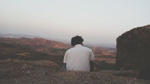 Rear view of man on landscape against sky