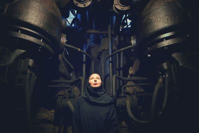 Woman standing against machinery