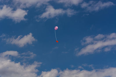 Low angle view of balloons against blue sky