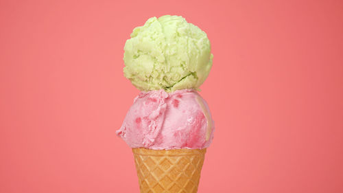 Close-up of ice cream cone against orange background