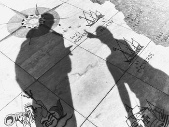 High angle view of people shadow on tiled floor
