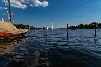 Sailboats moored in sea against sky