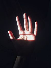 Close-up of human hand against black background