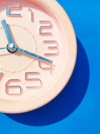 High angle view of clock on blue background