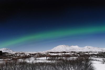 Scenic view of snowcapped mountains against sky at night