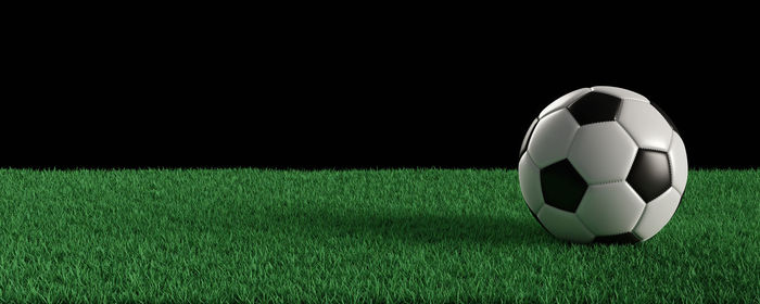 Close-up of ball on field against black background