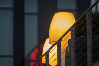 Low angle view of illuminated lamp against building at night