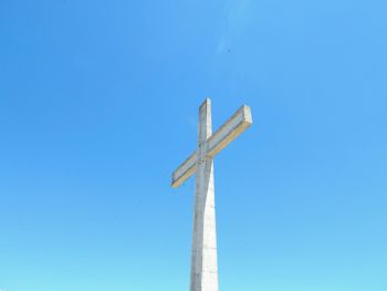 Low angle view of windmill against clear blue sky