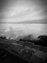 High angle view of city by sea against sky