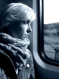 Close-up of woman looking through window