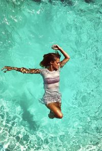 High angle view of woman floating on water in swimming pool