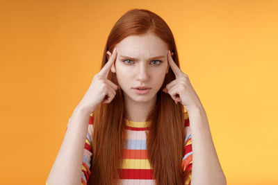 Portrait of young woman against wall