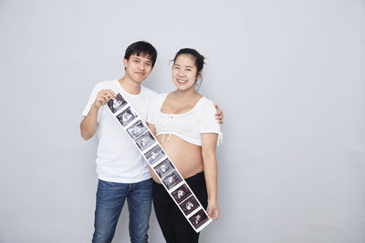 Portrait of friends standing against white background