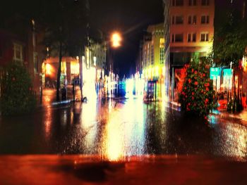 Illuminated city street during rainy season at night